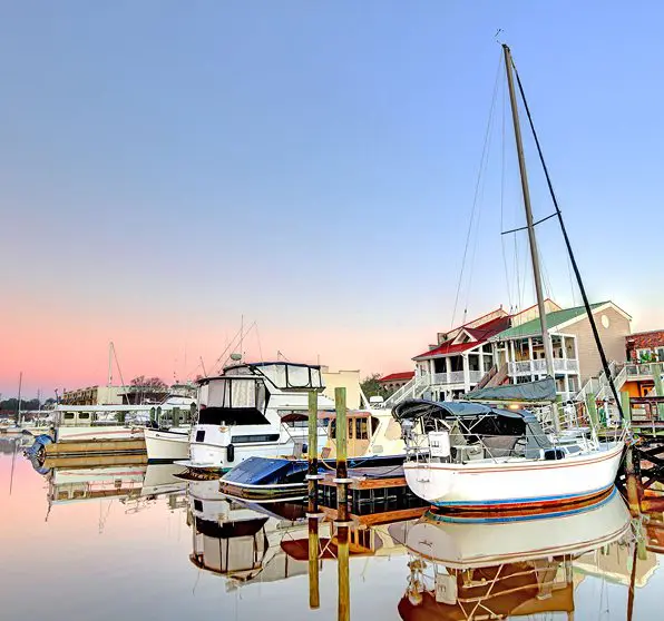Boats docked at a marina during sunset.