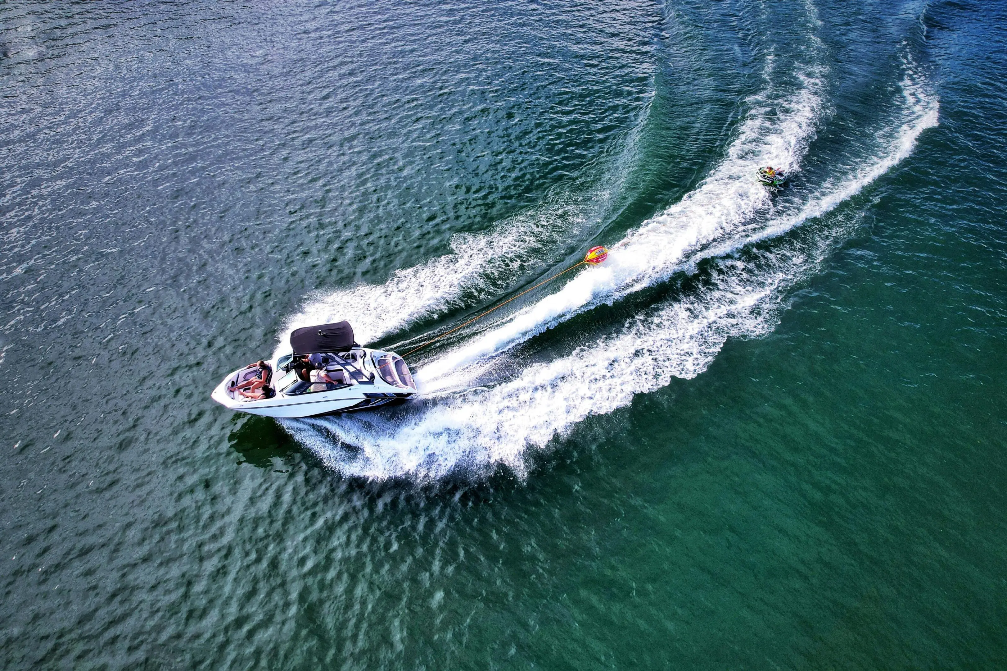A boat making sharp turns on the water, creating white wakes.