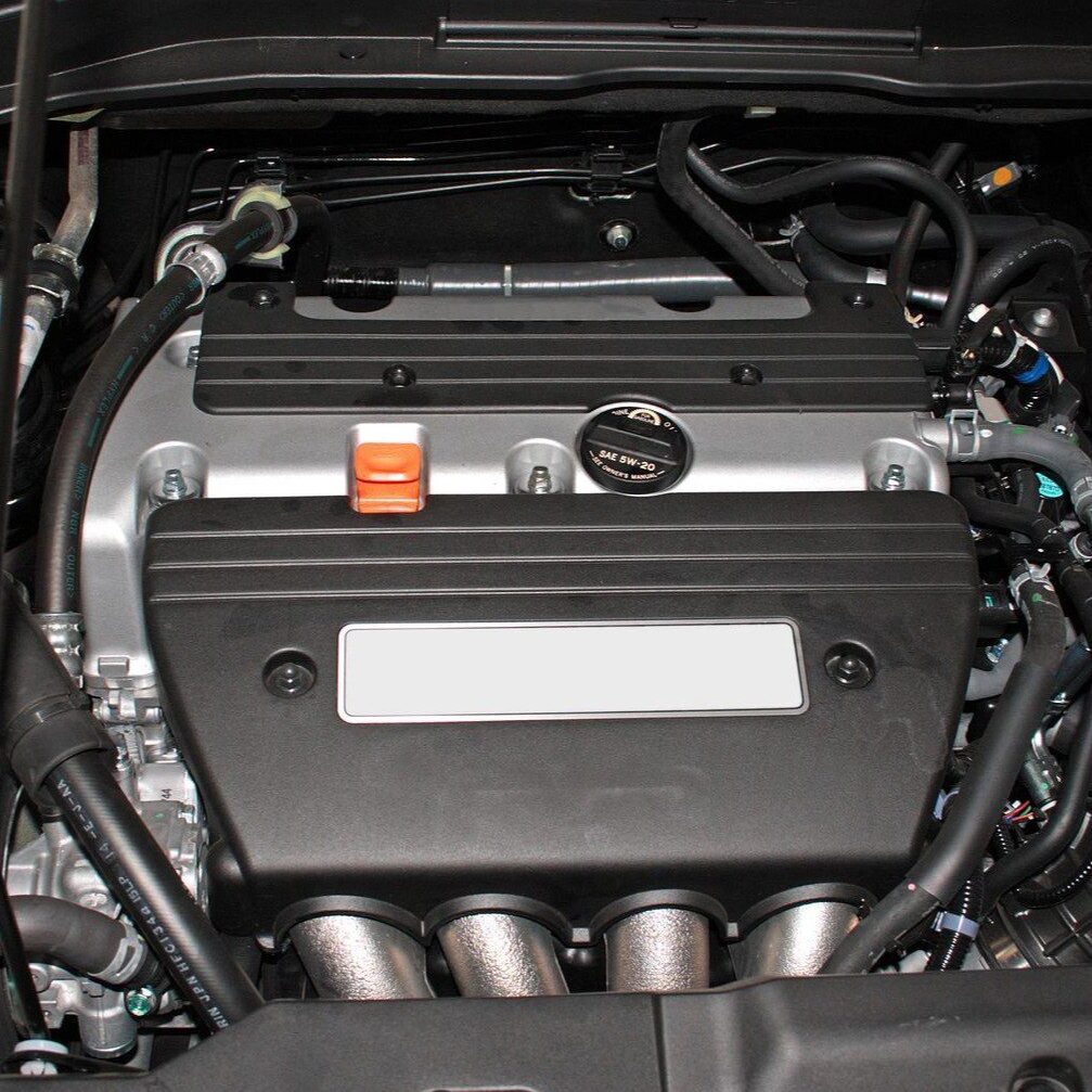 A clean modern car engine with visible components and hoses.